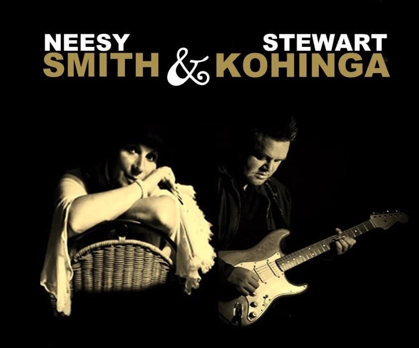 Photo/banner for Neesy Smith and Stewart Kohinga. Black background, white and gold writing. Photo of Neesy sitting on a chair backwards with arms resting on the top of the chair. Stewart playing his guitar.