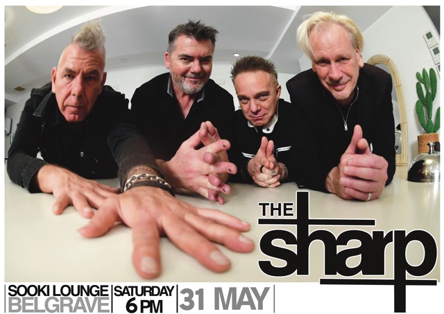 Close up fish eye lens colour photo of the band The Sharp. All members close together looking at the camera while leaning on a cream coloured kitchen bench.